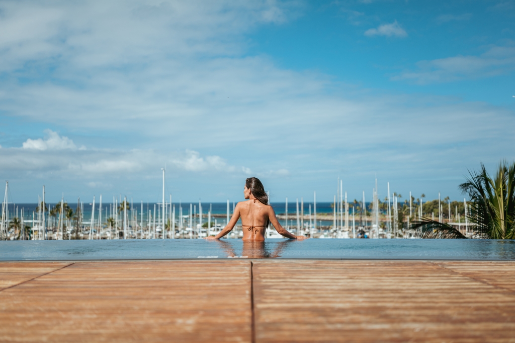 A woman looks out on the water from the Prince Waikiki infinity pool